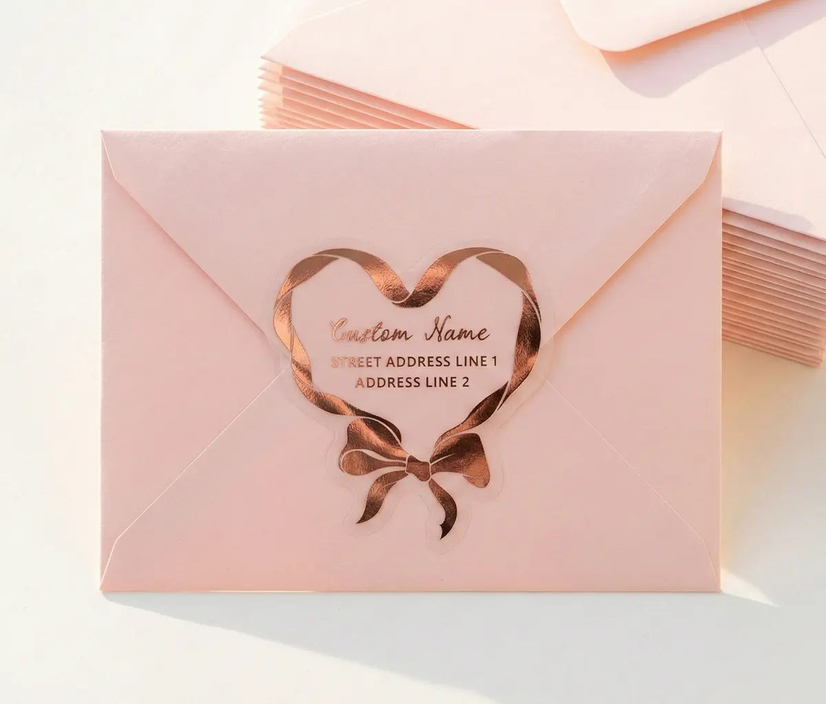 Return address label printed in rose gold foil applied to a pink color envelope with custom die cut coquette heart shape.