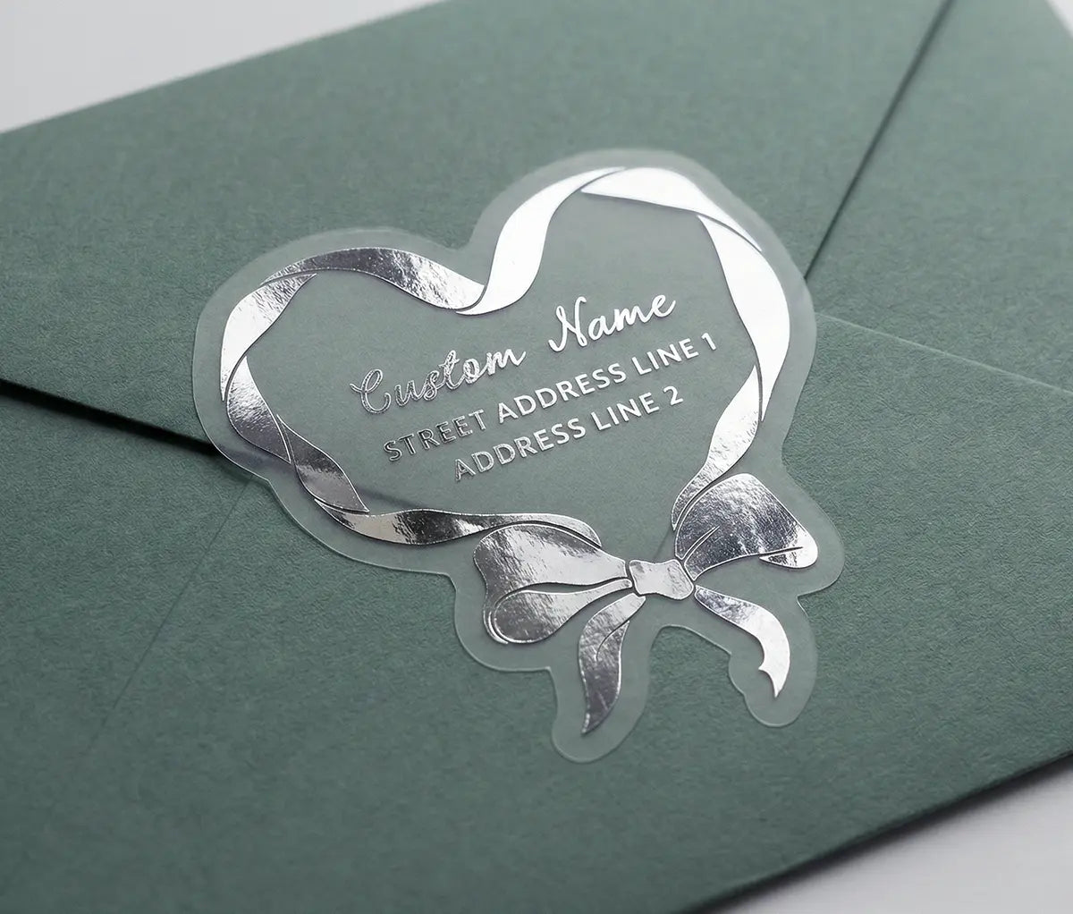 Return address label printed in silver foil applied to a sage green colour envelope with custom die cut coquette heart shape.