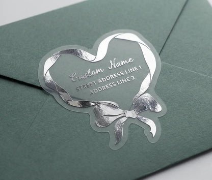 Return address label printed in silver foil applied to a sage green colour envelope with custom die cut coquette heart shape.