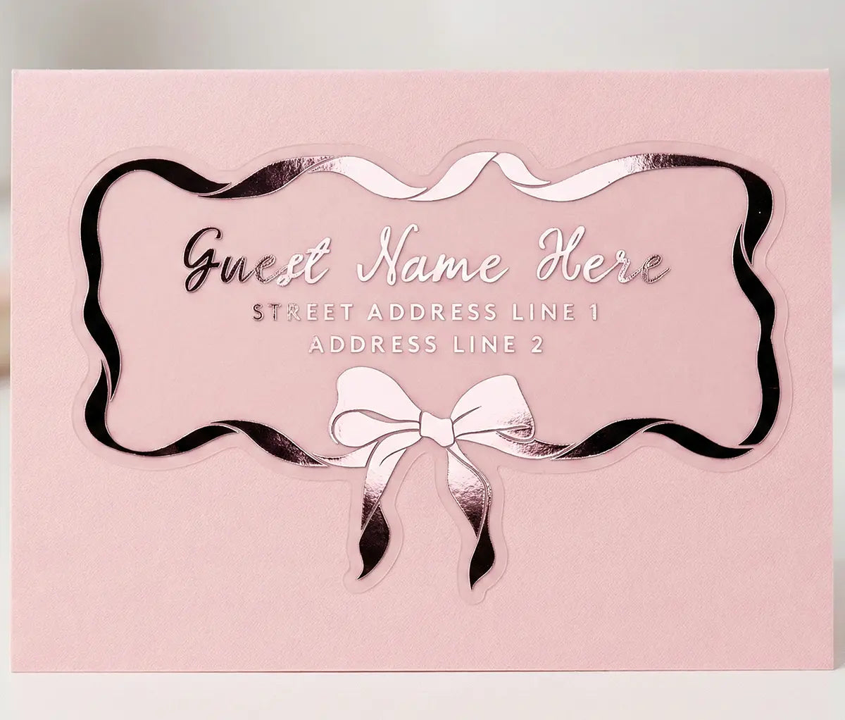 Guest address label applied to a pink colour envelope with custom die cut bow and ribbon shape