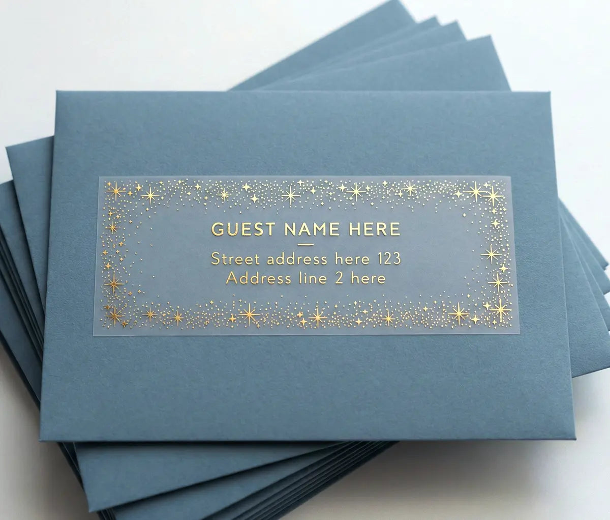 Stack of blue envelopes with recipient address labels and stellar frame printed in gold foil applied to them.