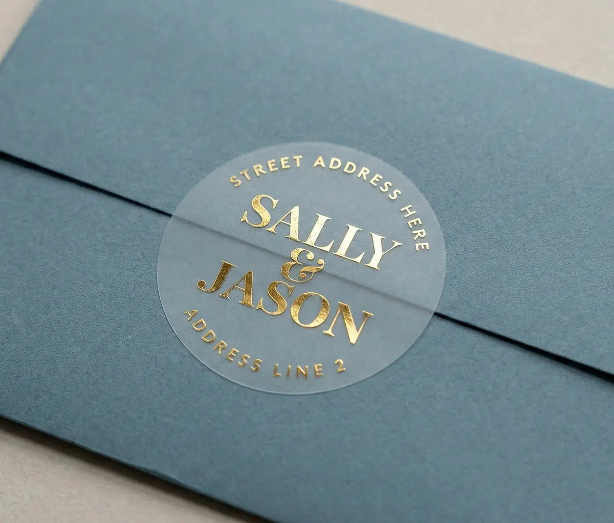 Slate Blue envelope with round Retun Address Label printed in gold foil on transparent matte vinyl.