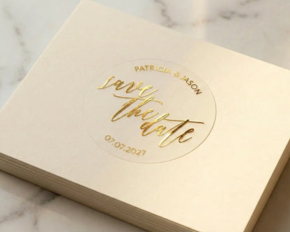 Gold foil print personalized 'save the date' sticker applied to a cream color card.